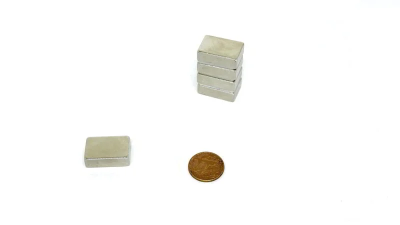 Ímã de neodímio retangular 30x20x10mm. Um ímã e uma pilha de quatro, com moeda de escala.