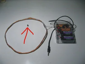 Diagrama de bobina circular com ponto e seta, e estojo Mitsubishi com fones de ouvido e cabo P2.