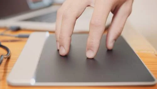 Sensel Morph: mão sobre a superfície tátil cinza do dispositivo retangular, demonstrando uma forma de usar.
