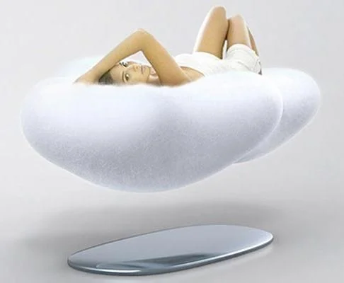 Sofá que flutua magneticamente, em formato de nuvem branca, com mulher deitada. Base oval espelhada.