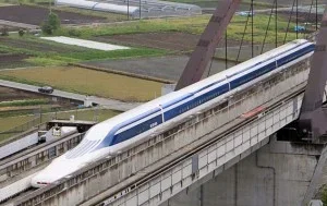 Trem bala japonês Shinkansen branco e azul em viaduto elevado. Representa projeto de transporte bem sucedido no Japão.
